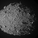 Close-up of the boulder-strewn asteroid Dimorphos, built from DART spacecraft final images, with the edge of Didymos at right