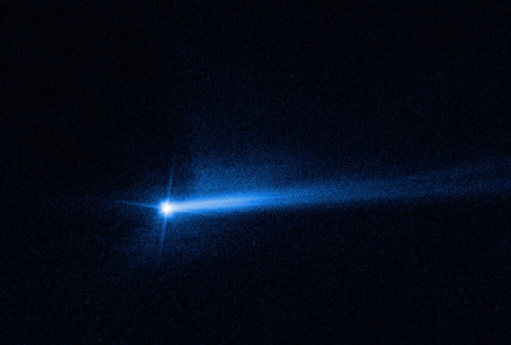 Hubble image of the Didymos asteroid system with two long dust tails streaming away after the DART impact